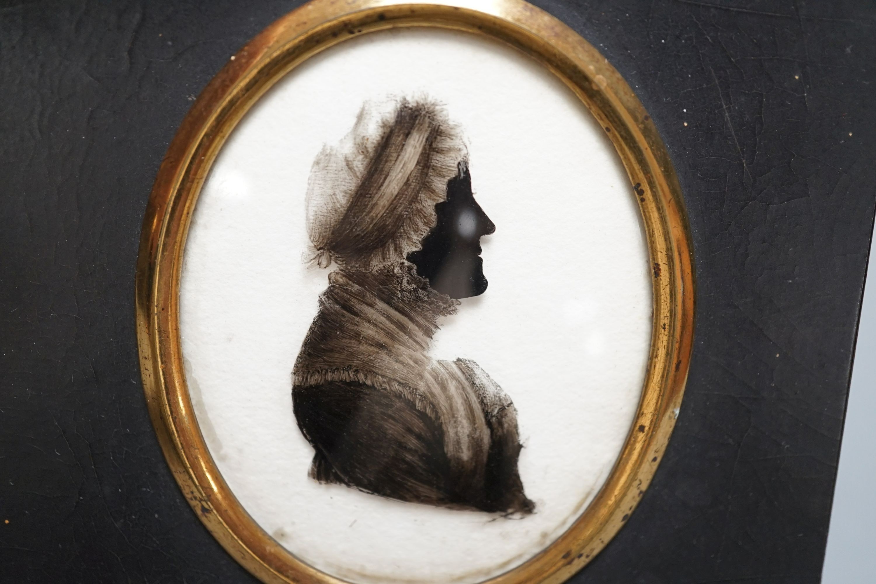 A Limoges style painted pottery plaque - Madonna and child, together with a Victorian reverse painted glass silhouette portrait